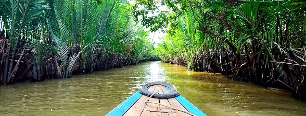 A small boat travelling along a Mekong Delta canal
