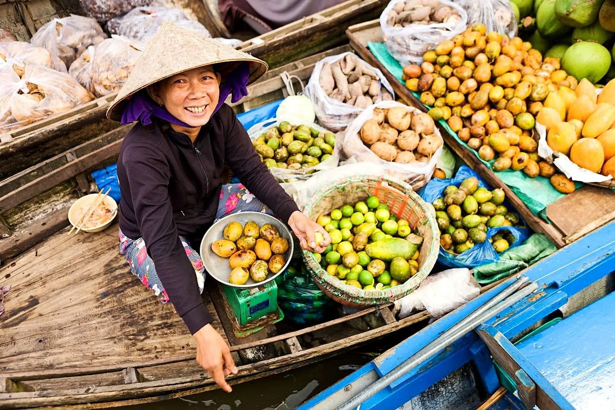 A fruit vendor selling produce from a boat in the Mekong Delta