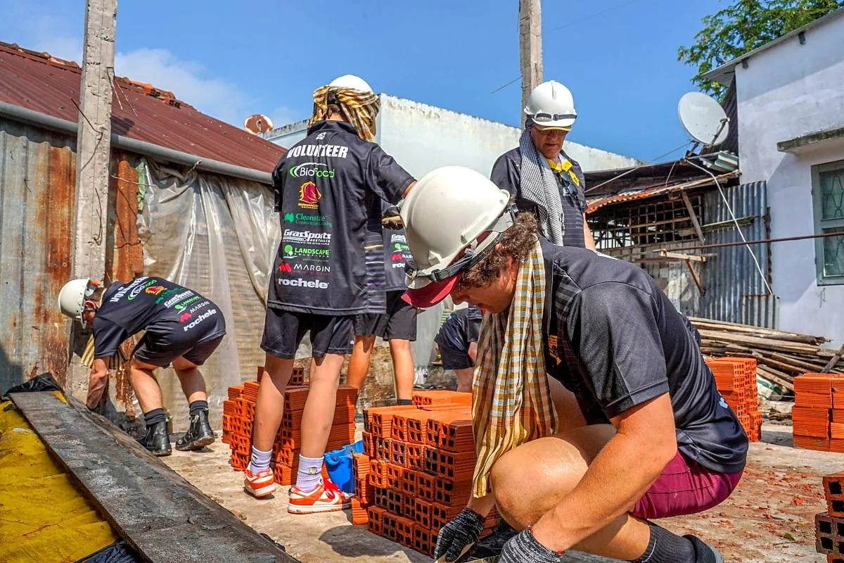 High school students helping build a brick house in the Mekong Delta