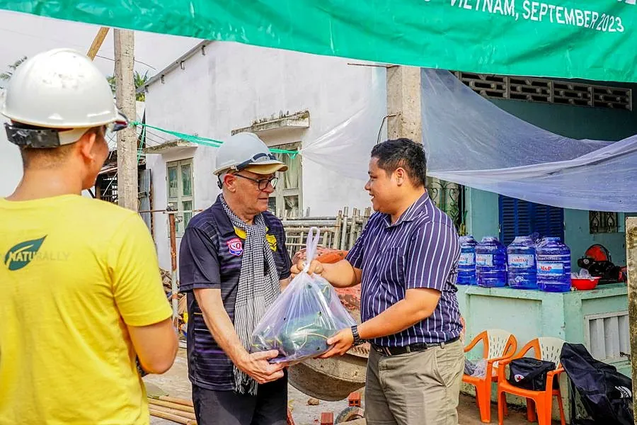 Students handing supplies to a community partner in the Mekong Delta