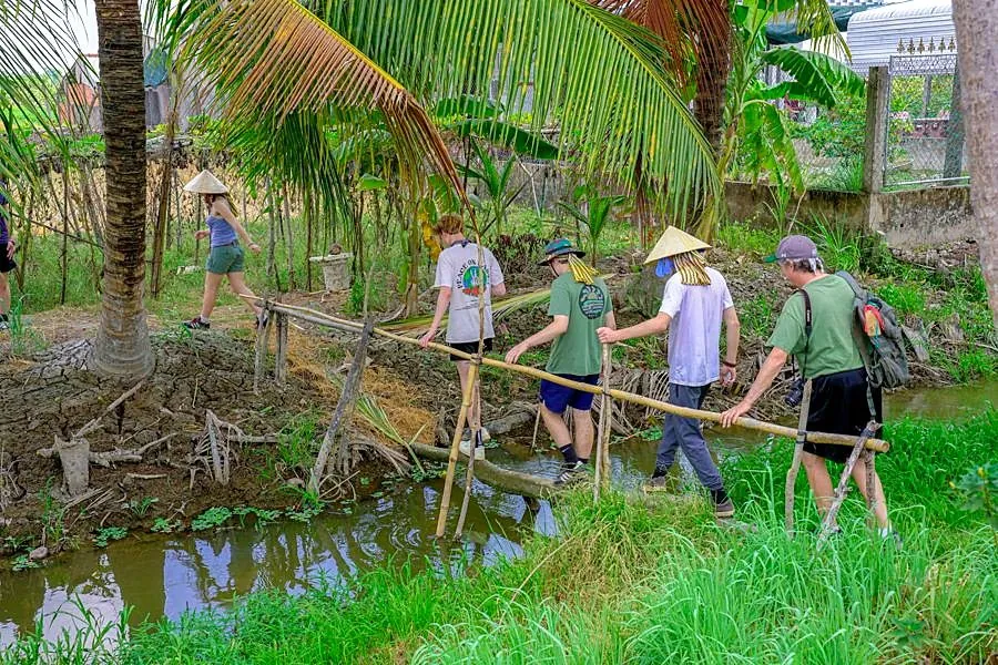 Students crossing a footbridge during a Mekong village stay