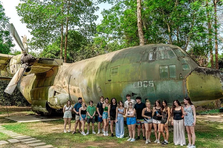 Students standing beside a transport aircraft at Ta Con Airbase