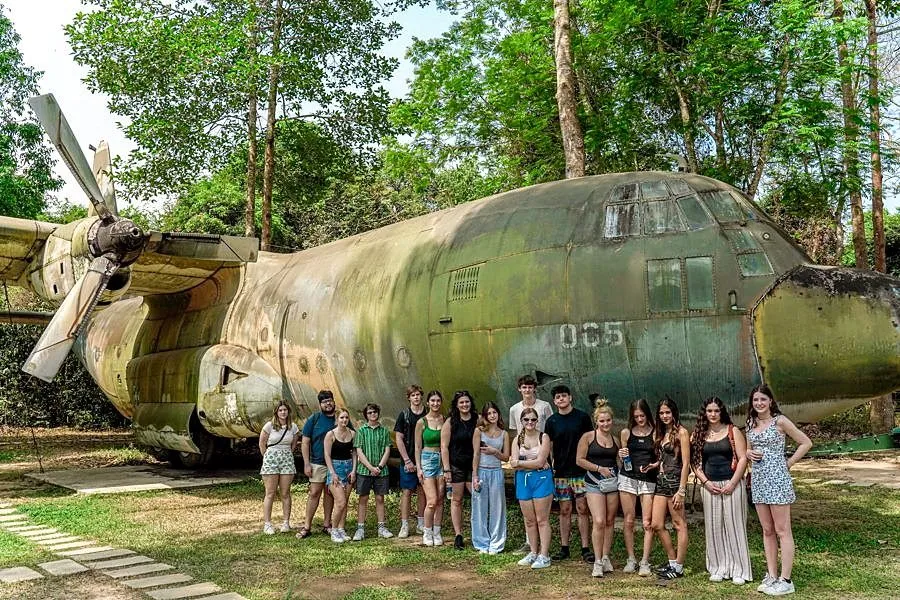 Students beside a transport aircraft at Ta Con Airbase