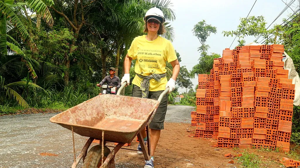 A construction worker carrying bricks at a Mekong Delta community project