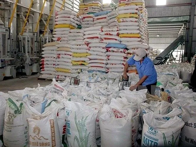 Rice sacks and workers inside a processing facility in Vietnam