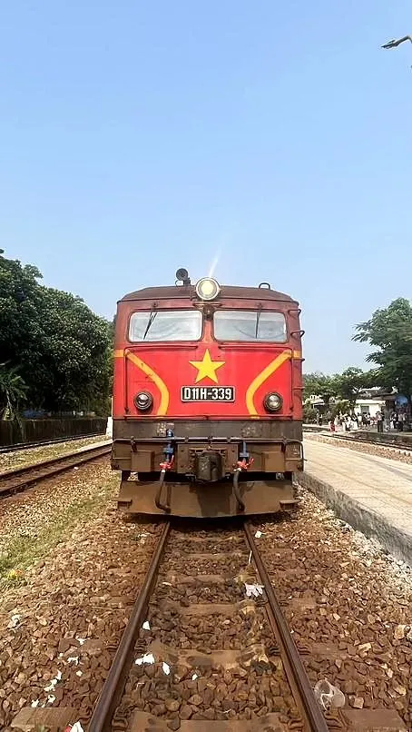 A red Vietnamese railway locomotive at a station